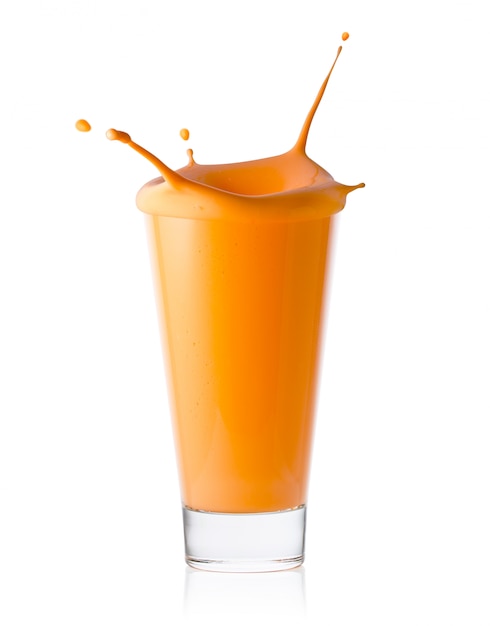 Un verre de smoothie aux agrumes ou aux carottes ou du yogourt avec des éclaboussures