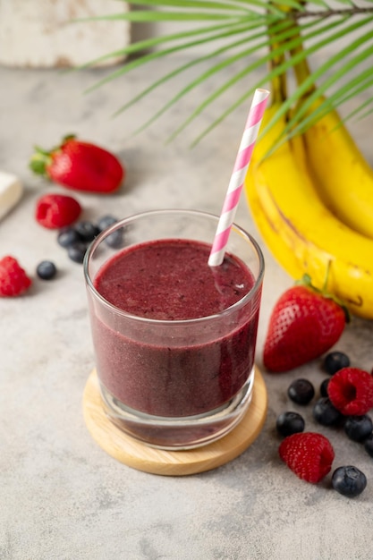 Verre de smoothie aux baies dans un verre fraise banane myrtille boisson saine