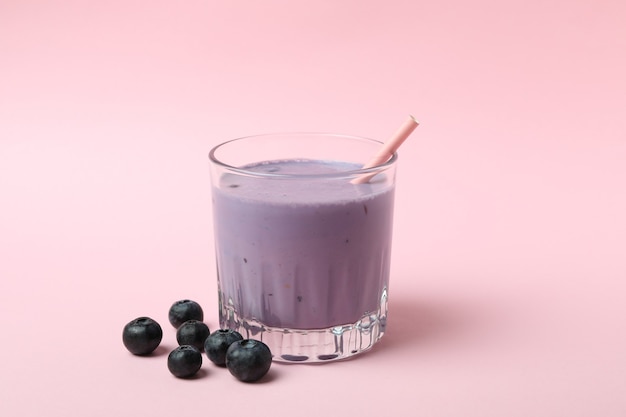 Verre de smoothie aux bleuets sur fond rose