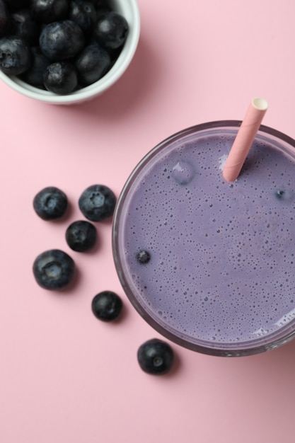 Verre de smoothie aux bleuets sur fond rose