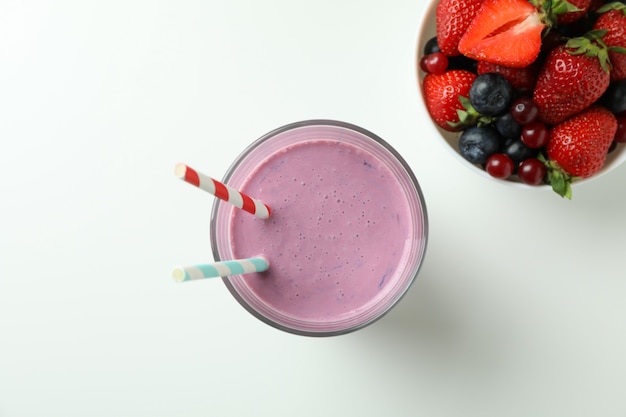 Verre de smoothie et ingrédients sur fond blanc