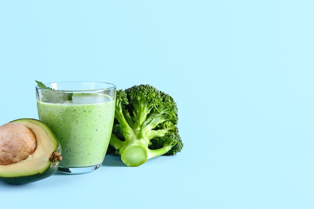 Verre de smoothie sain avec avocat et brocoli sur la surface de couleur