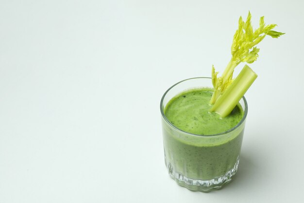 Verre de smoothie vert avec Ñ elery sur fond blanc