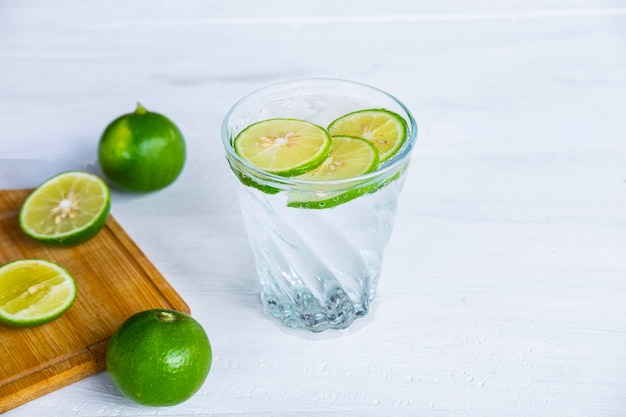 Un verre de soda, citron et citron vert sur la table