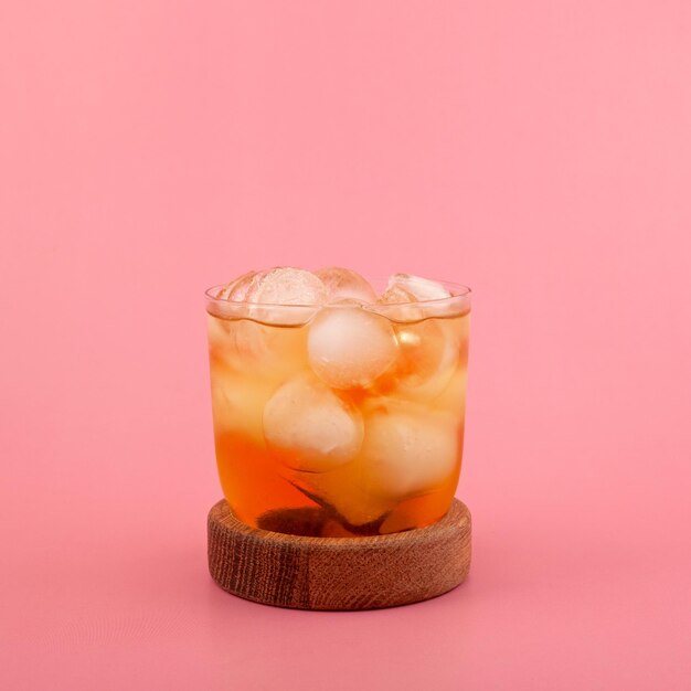 Photo verre de spritzer apple ou apfelschorle sur fond rose spritzer fait maison avec des glaçons