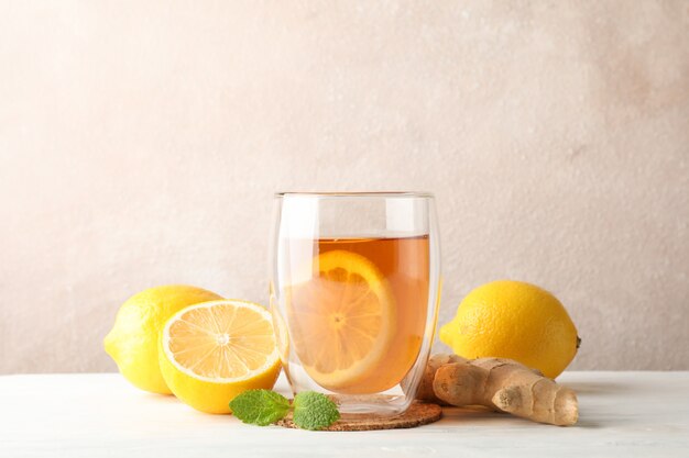 Verre de thé au citron, menthe, miel, louche et gingembre sur bois, copie espace