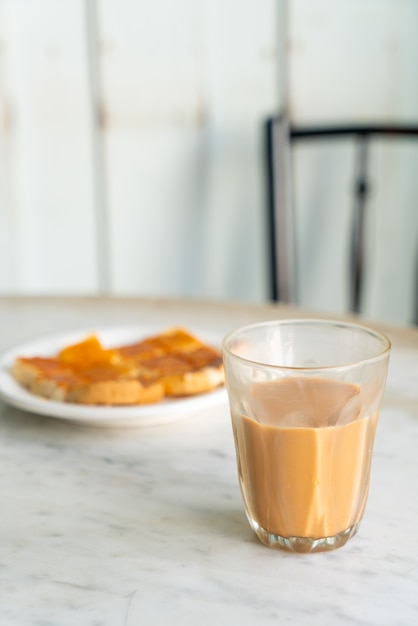 Verre à thé au lait thaï chaud sur la table