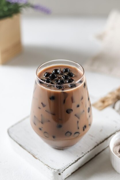 Un verre de thé glacé avec des myrtilles dedans.