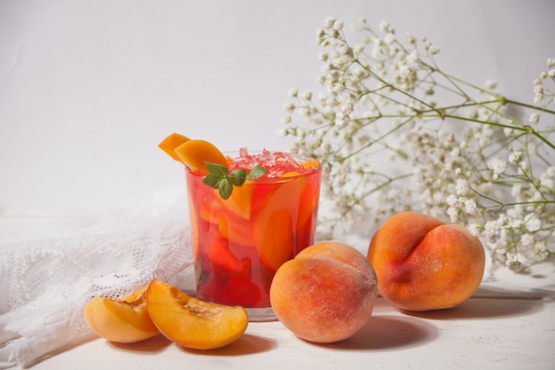 Verre de thé glacé sucré à la pêche fait maison frais ou cocktail, limonade à la menthe. Boisson rafraîchissante. Fête d'été.