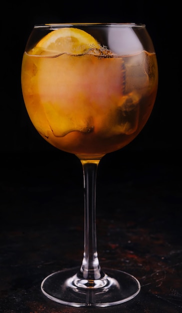 Verre transparent avec une boisson alcoolisée orange vif et des glaçons