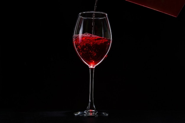 Un verre de vigne rouge sur fond noir