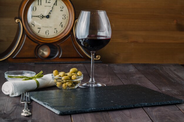 Verre à vin aux olives sur table