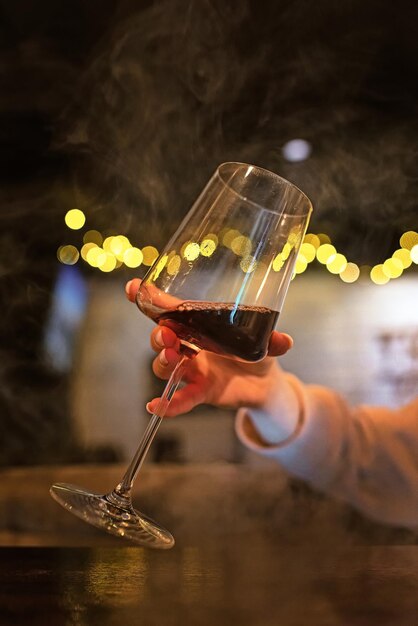 un verre de vin. bar. fumée. la fille tient le vin