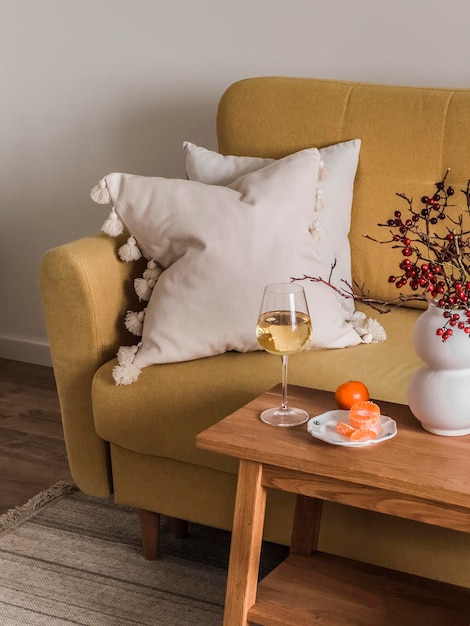 Un verre de vin blanc mandarine un simple apéritif sur une table en bois à côté du canapé dans le salon