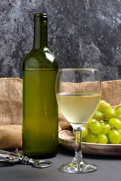 Verre à vin blanc avec des raisins dans une atmosphère de cave