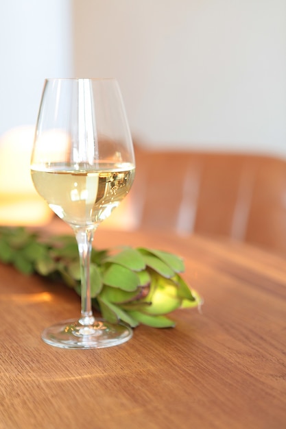 Verre de vin blanc à la table en bois du restaurant. Image horizontale - lumières du soleil à l'intérieur du restaurant, personne. comptoir de bar arrière-plan flou