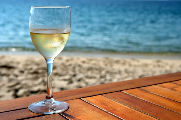 Verre de vin blanc sur la table de plage méditerranéenne