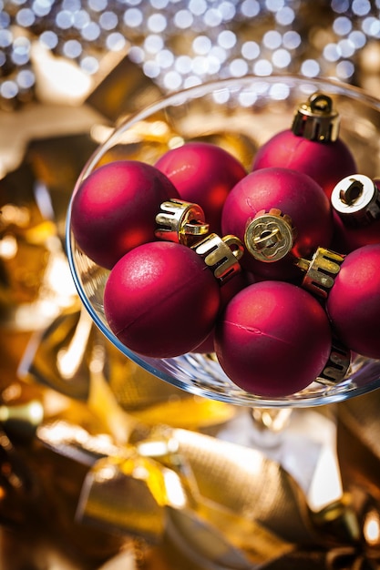 Verre à vin avec des boules de Noël rouges.