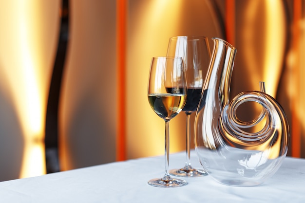 Verre de vin et une carafe sur une table avec une nappe blanche.