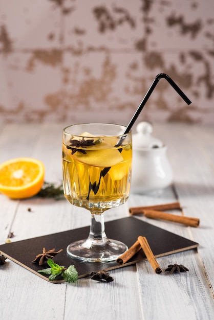 Un verre de vin chaud blanc avec des oranges sur fond de bois