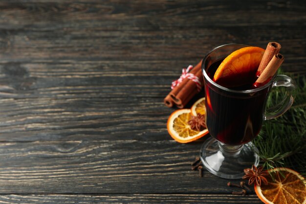 Verre de vin chaud et ingrédients sur table en bois