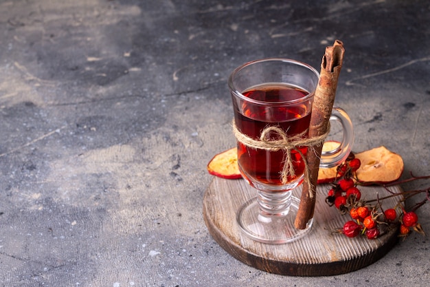 Un verre de vin chaud se dresse sur un espace de copie de planche de bois ronde