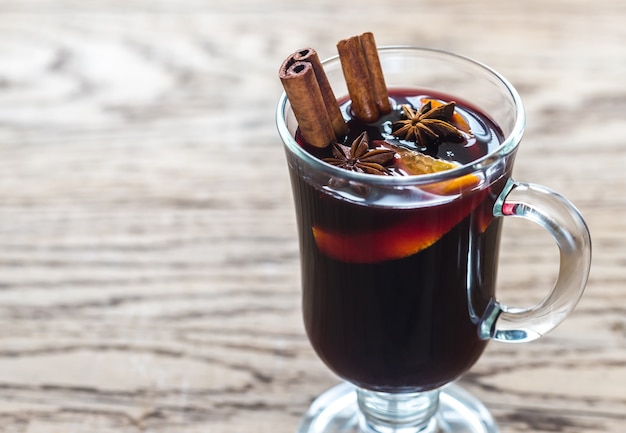 Verre de vin chaud sur la surface en bois