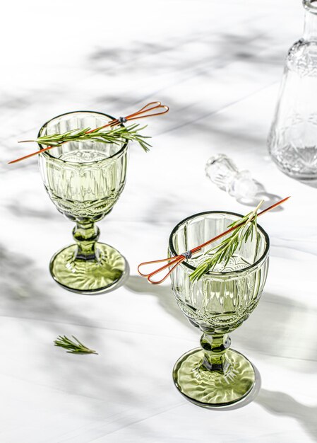 Photo verre de vin en cristal vert sur fond blanc avec l'ombre des feuilles