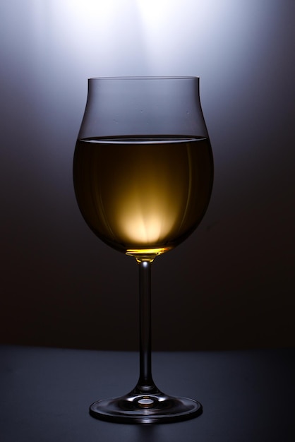 Un verre de vin est éclairé sur un fond noir.