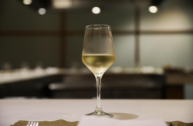 Un verre de vin est posé sur une table dans un restaurant.