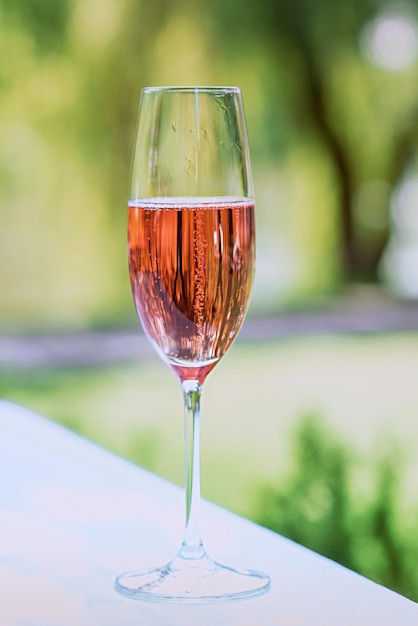 Verre de vin mousseux rose en plein air Célébration du concept de voyage relaxant