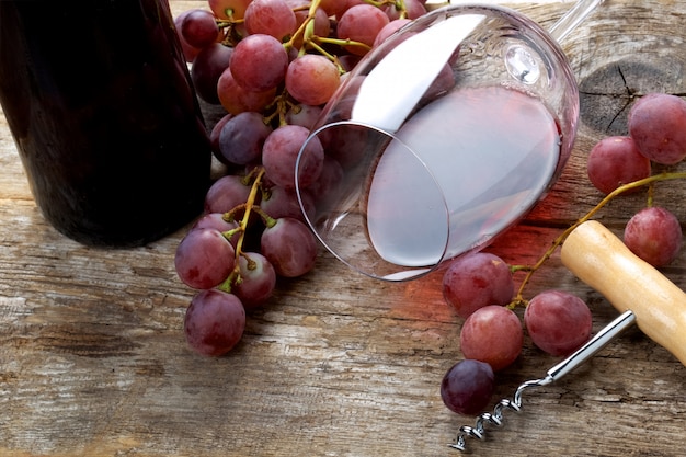 Verre de vin avec raisins sur table en bois