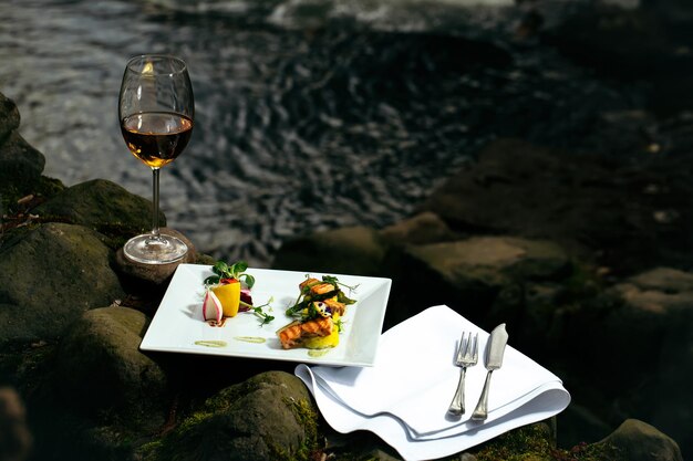 Verre de vin et repas près de l'eau