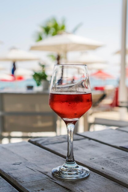 Un verre de vin rosé avec un arrière-plan flou sur une table en bois