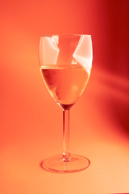 Verre de vin rose sur fond rouge avec des lumières sur le verre