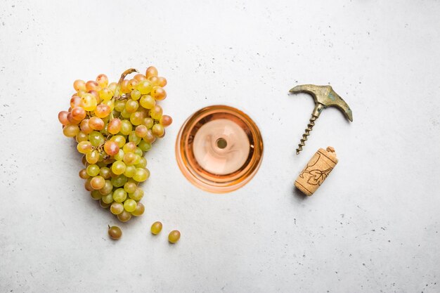 Verre de vin rose et raisins mûrs sur fond blanc vue de dessus