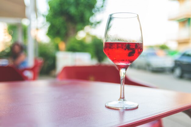 Verre de vin rosé sur la table dans le café de rue Tonification vintage Mise au point sélective