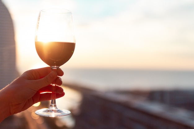 Un verre de vin rouge au coucher du soleil.