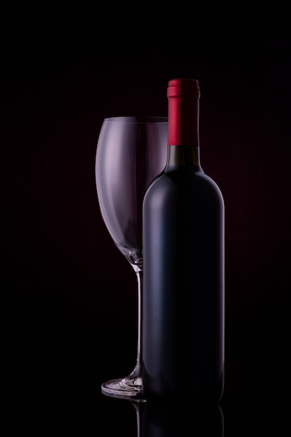 Verre à vin rouge et une bouteille de vin avec des reflets