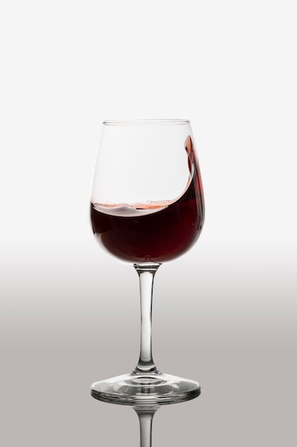 Verre de vin rouge faisant sensation avec le vin et le fond dégradé