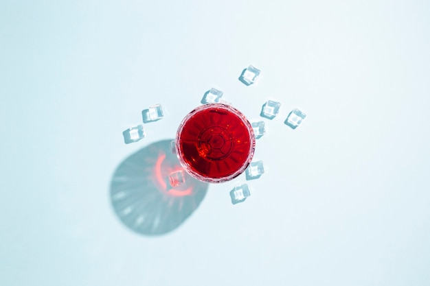 Verre à vin rouge, glaçons sur la table