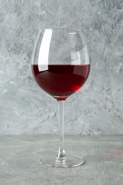 Verre de vin rouge sur une table texturée grise