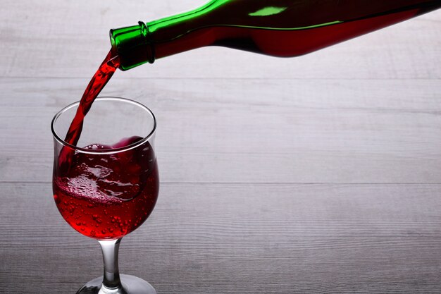 verre de vin rouge. verre de vin sur un fond en bois clair