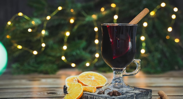 Verre de vin rouge vin chaud à la cannelle et à l'orange sur une planche à découper sur une table