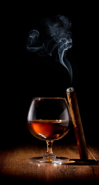 Verre à vin de scotch et cigare sur table en bois