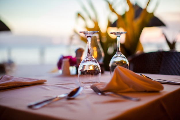 Verre à vin vide gros plan sur la table au coucher du soleil