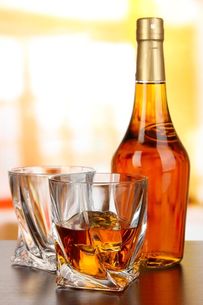 Photo verre de whisky avec bouteille sur fond sombre
