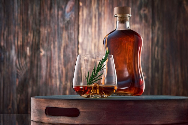 Verre de whisky et une bouteille sur la table en bois