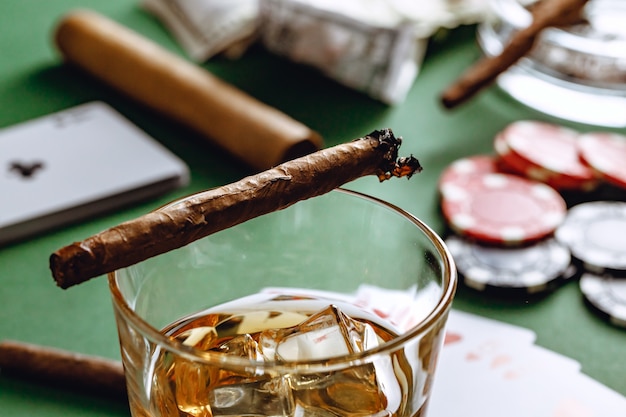 Photo verre de whisky cigare cubain et chips sur table