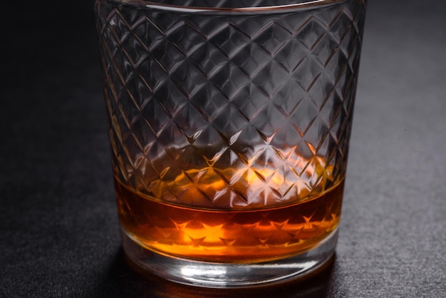 Un verre de whisky ou de cognac sur une table en béton noir Moment de détente